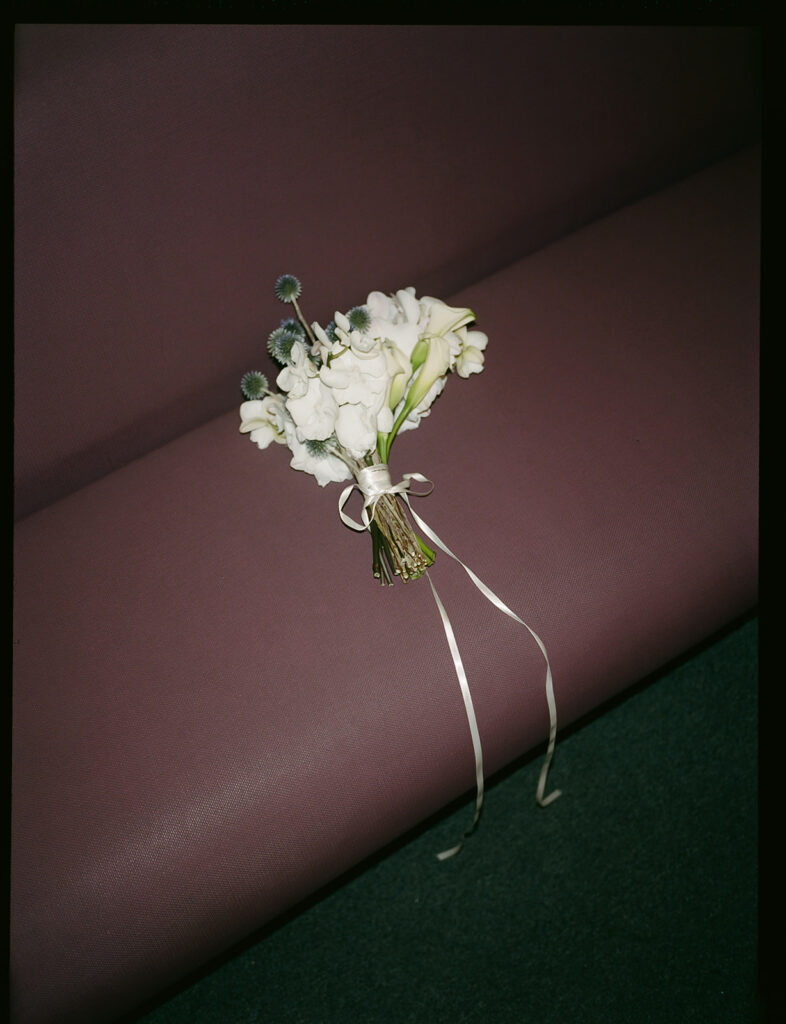 Bridal bouquet on the couch of the Manhattan Courthouse along with marriage requirement details.