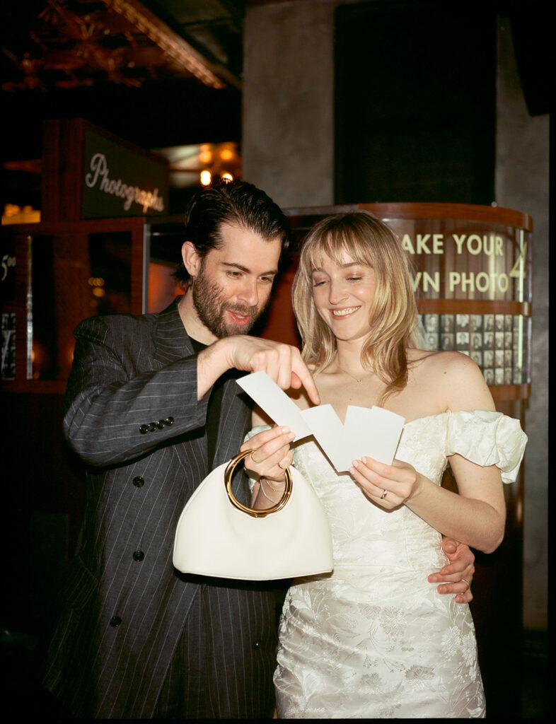 After eloping, the couple check their photos from a Manhattan film photobooth.