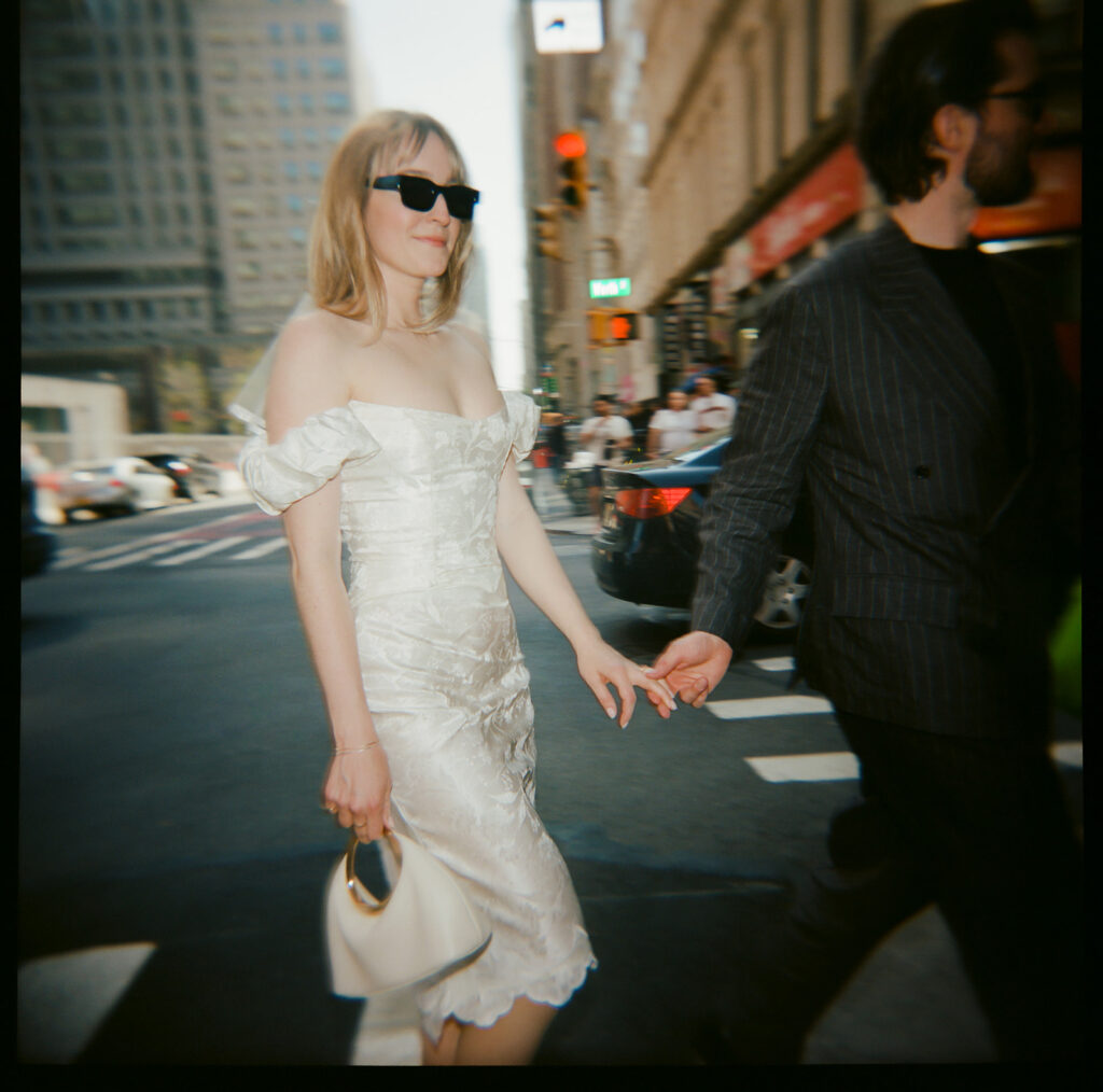 Fresh of eloping, newlyweds walk through the streets of downtown Manhattan.