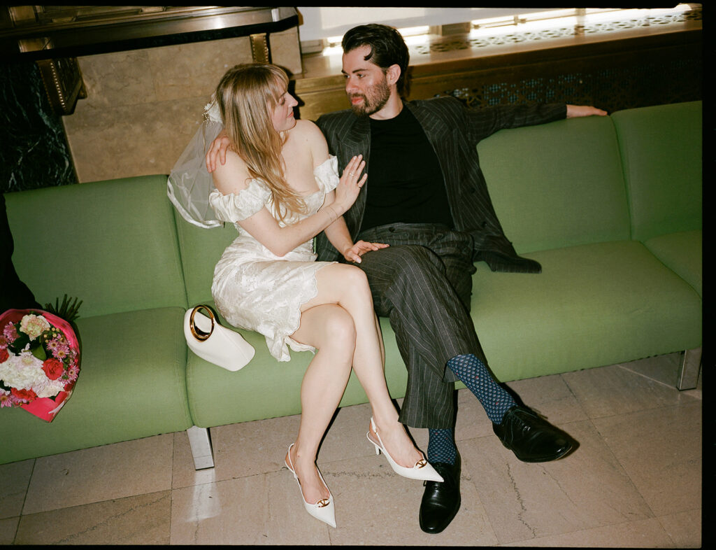 Taking a seat on the iconic Manhattan Courthouse green couch, Sarah and Ben wait for their number to be called.