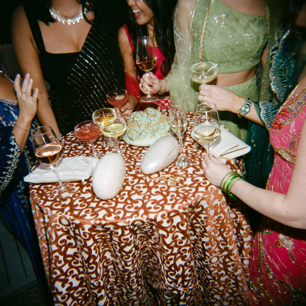 Guests at an Indian American wedding weekend share a drink. 