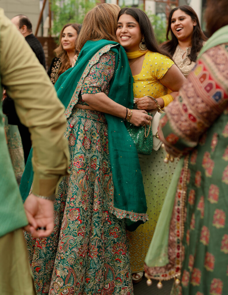 Wedding guests a hug during the sangeet. 