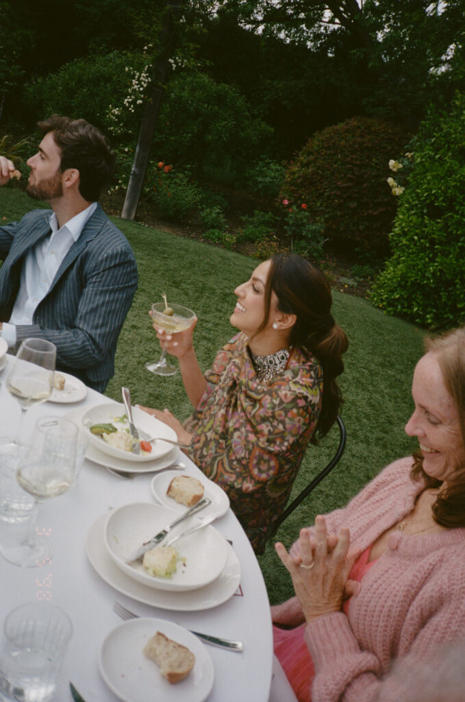 Bride and groom with family at the rehearsal dinner during their wedding weekend.
