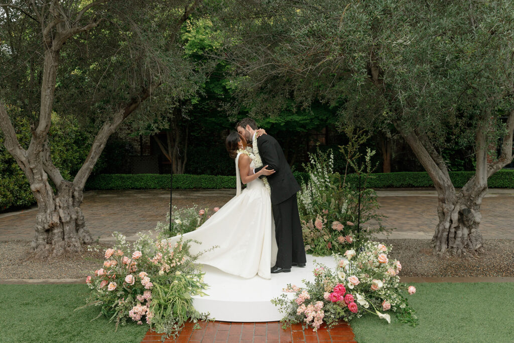 Bride and groom share their first kiss during the ceremony of their Indian American wedding weekend. 