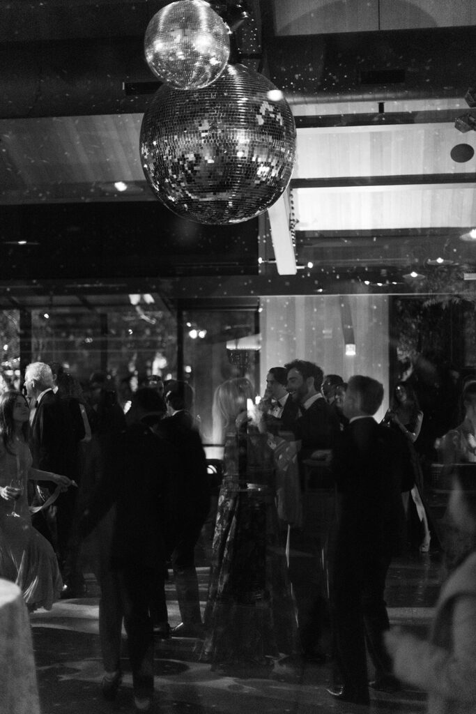 The disco balls spun overhead, sending tiny points of light drifting over guests’ faces.